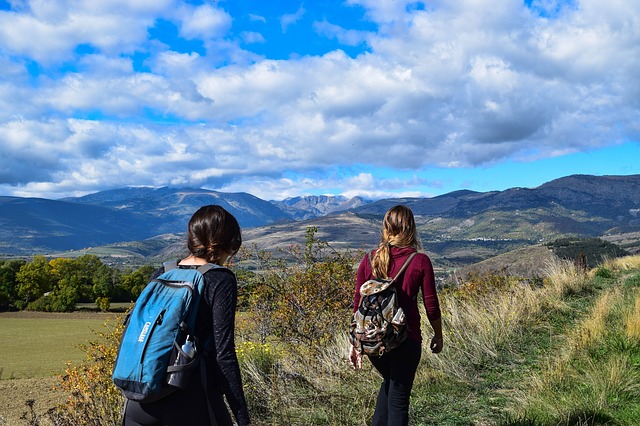Dívky jdoucí v horské krajině-turistika